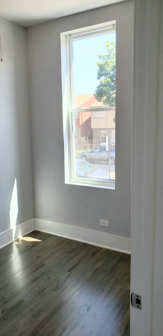 2030 West 21st Street Chicago, IL 60608 - Photo 10 of 19 a view of an empty room with wooden floor and a window