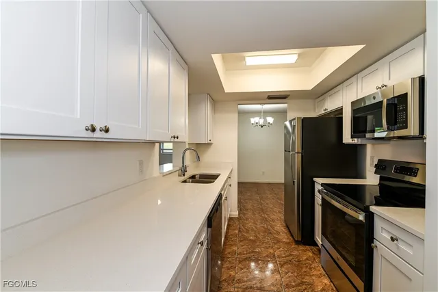 a kitchen with kitchen island granite countertop a sink stainless steel appliances and cabinets