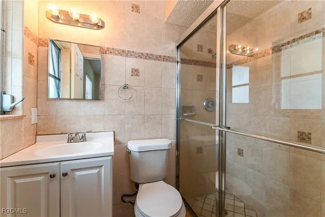 a bathroom with a shower sink vanity and toilet