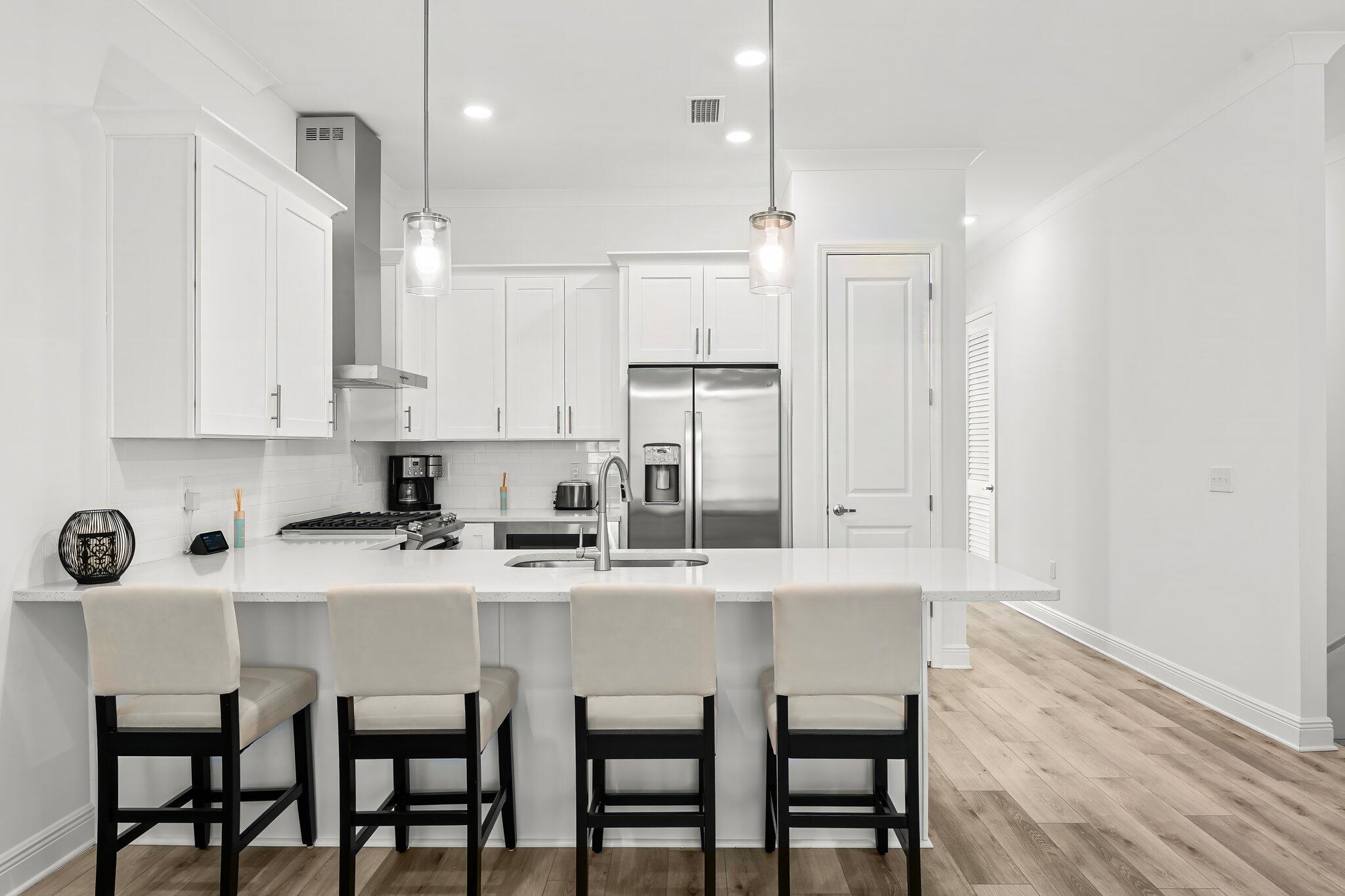 22 Kara Lake Drive Santa Rosa Beach, FL 32459 - Photo 19 of 44 a kitchen with kitchen island granite countertop a table chairs sink and cabinets