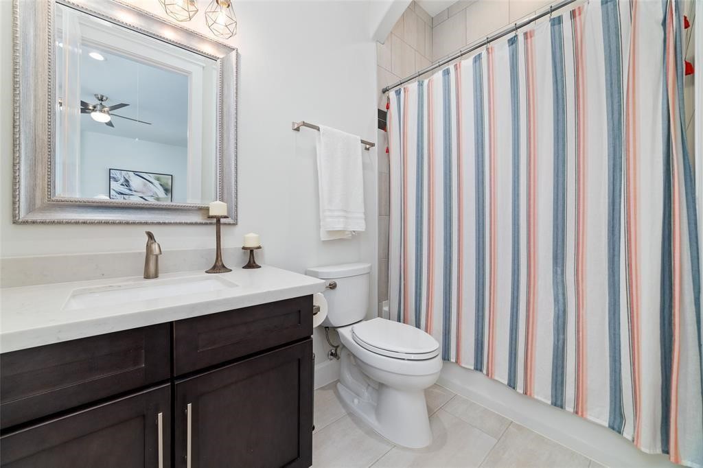 710 Delano Street, Unit A Houston, TX 77003 - Photo 21 of 32 The bathroom features a modern vanity with a sleek countertop and stylish fixtures. It has a large framed mirror, a toilet, and a bathtub. The space is well-lit and has a clean, contemporary design.