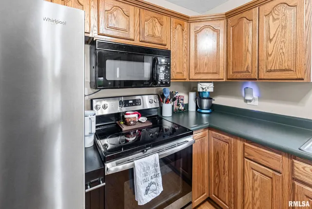 a kitchen with stainless steel appliances granite countertop a stove microwave and cabinets
