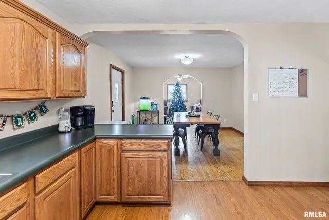 a kitchen with stainless steel appliances granite countertop dining table chairs and a refrigerator