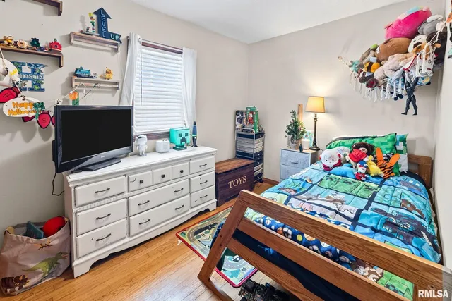 a bedroom with a bed window and a dresser in it