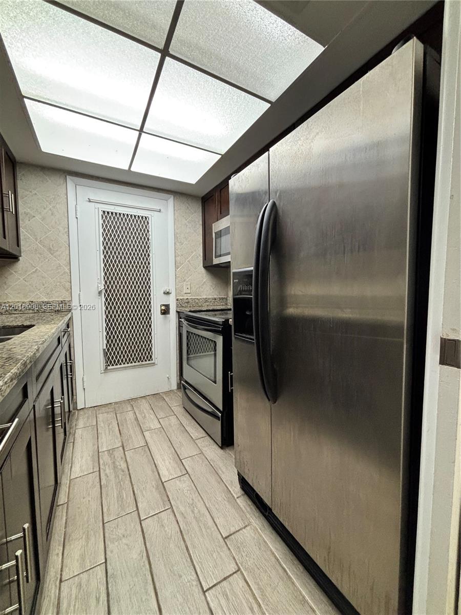 1480 East Sample Road, Unit 209 Pompano Beach, FL 33064 - Photo 12 of 24 a kitchen with granite countertop a refrigerator and a stove