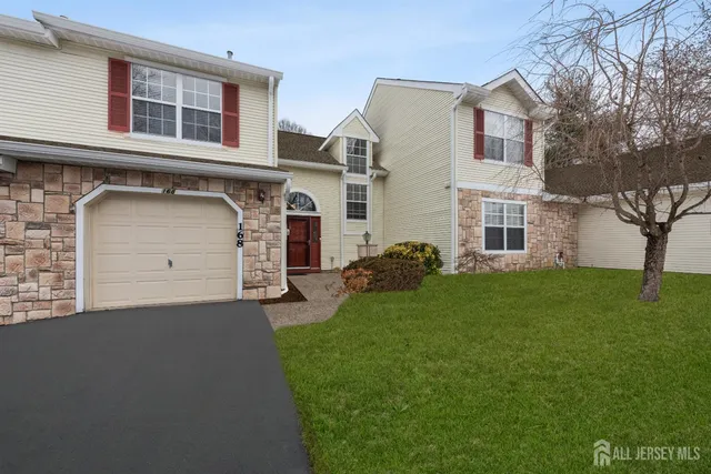 a front view of a house with a garden and garage