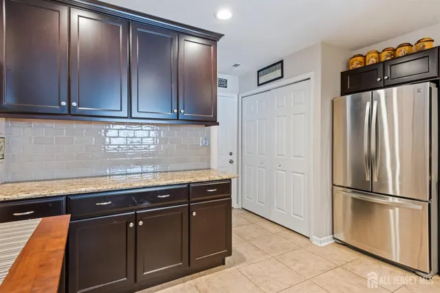 a kitchen with stainless steel appliances granite countertop a refrigerator and a sink