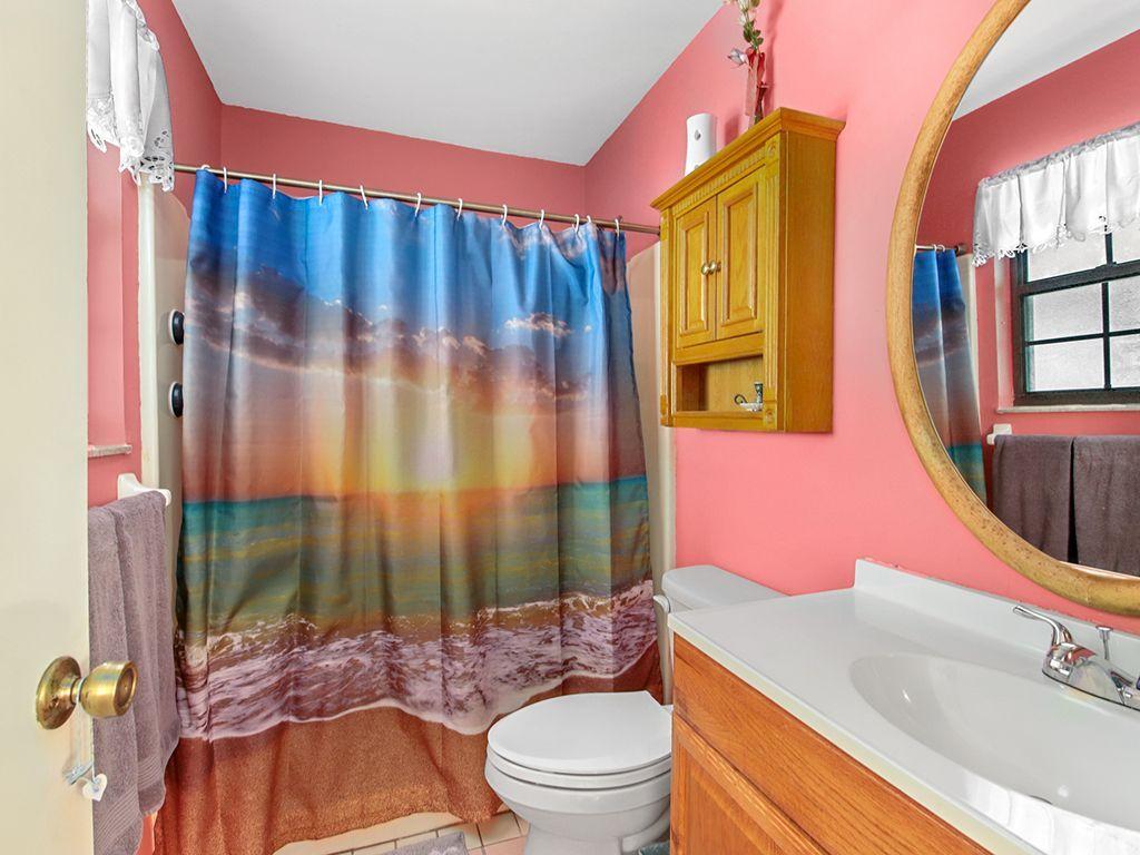 5931 Southeast Pine Drive Stuart, FL 34997 - Photo 13 of 24 a bathroom with a sink a toilet and shower curtain