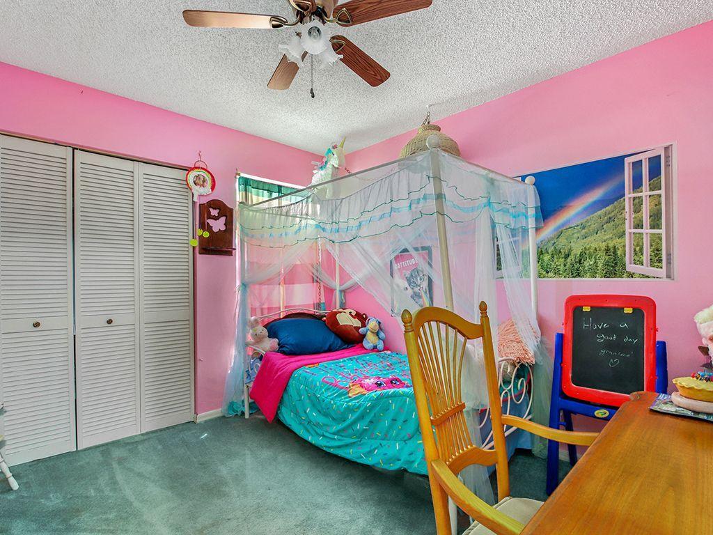 5931 Southeast Pine Drive Stuart, FL 34997 - Photo 14 of 24 a bedroom with furniture and a bed