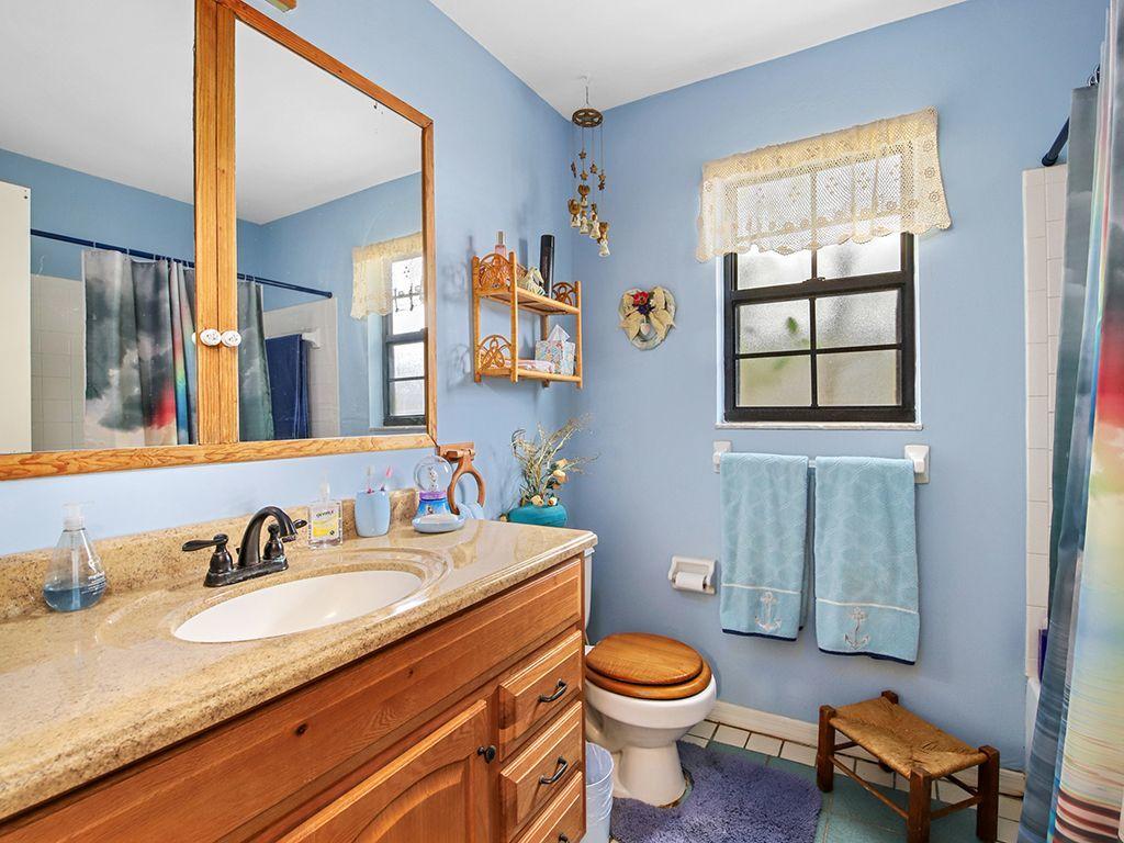 5931 Southeast Pine Drive Stuart, FL 34997 - Photo 16 of 24 a bathroom with a granite countertop sink toilet and mirror