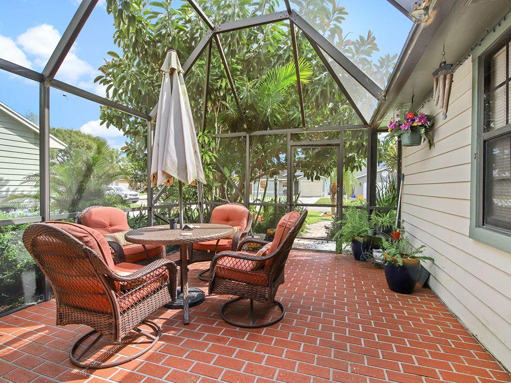 5931 Southeast Pine Drive Stuart, FL 34997 - Photo 22 of 24 a outdoor living space with furniture potted plant and a large window