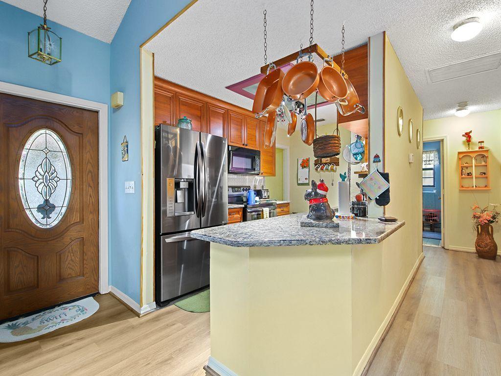 5931 Southeast Pine Drive Stuart, FL 34997 - Photo 5 of 24 a view of living room with granite countertop furniture a flat screen tv and a clock