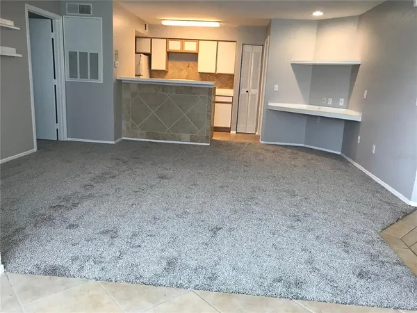 an empty room with a chandelier fan