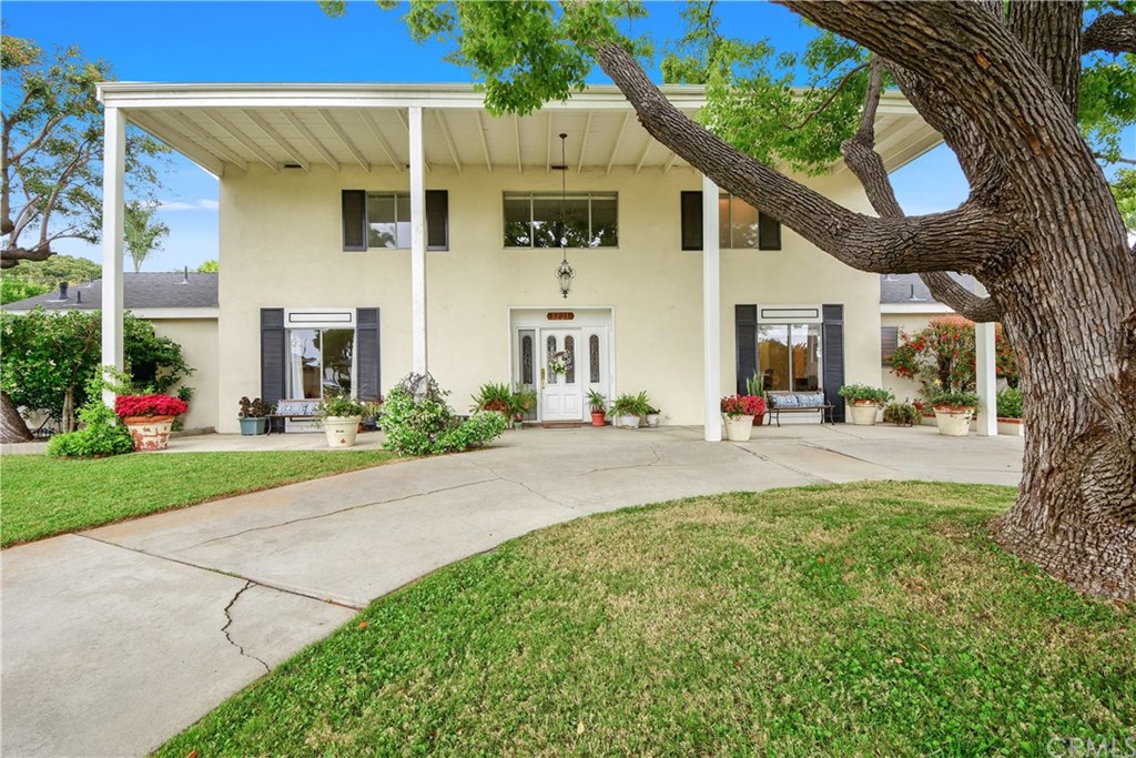 1221 Huntridge Road North Tustin, CA 92705 - Photo 1 of 1 This stately two story has an enormous front porch area accented with colorful potted plants.