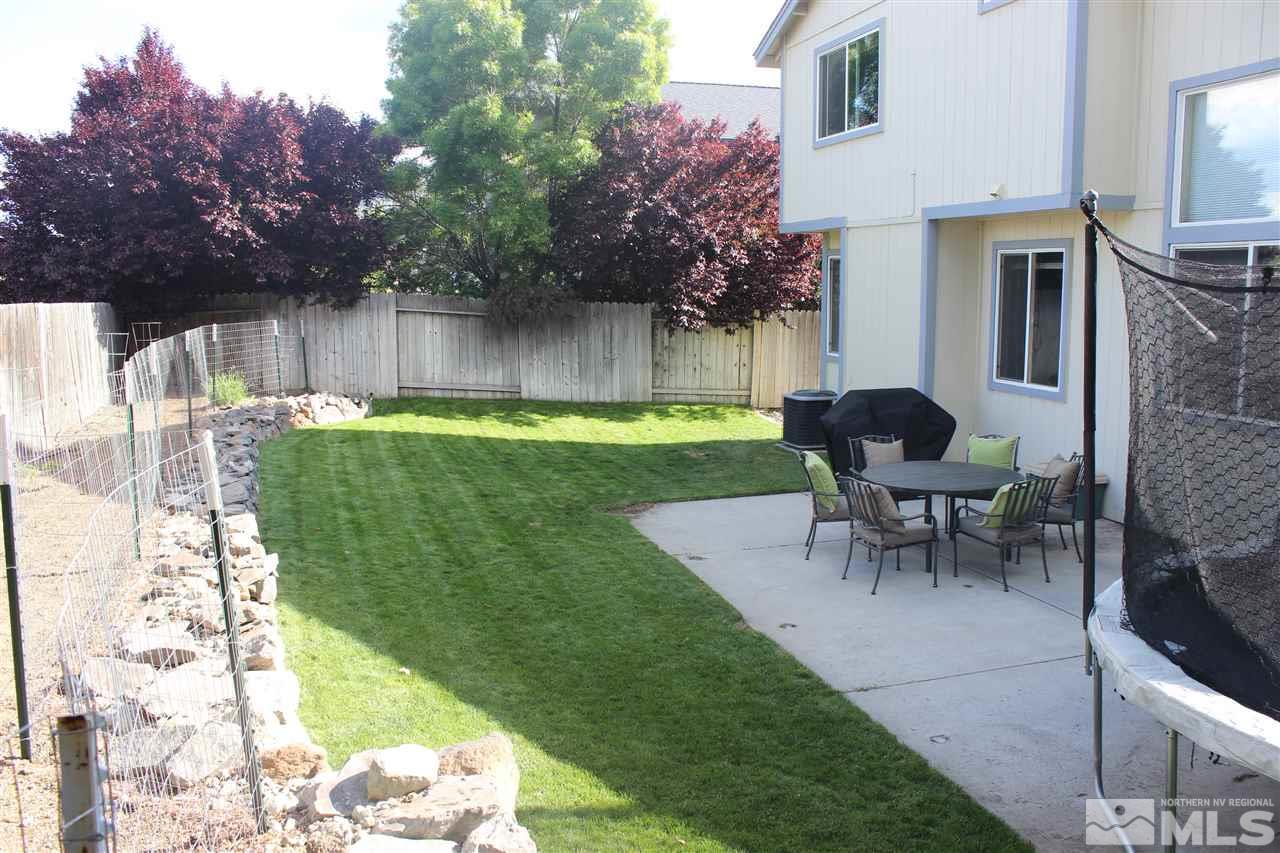 1458 Backer Way Reno, NV 89523 - Photo 21 of 25 a view of a backyard with table and chairs potted plants and a large tree