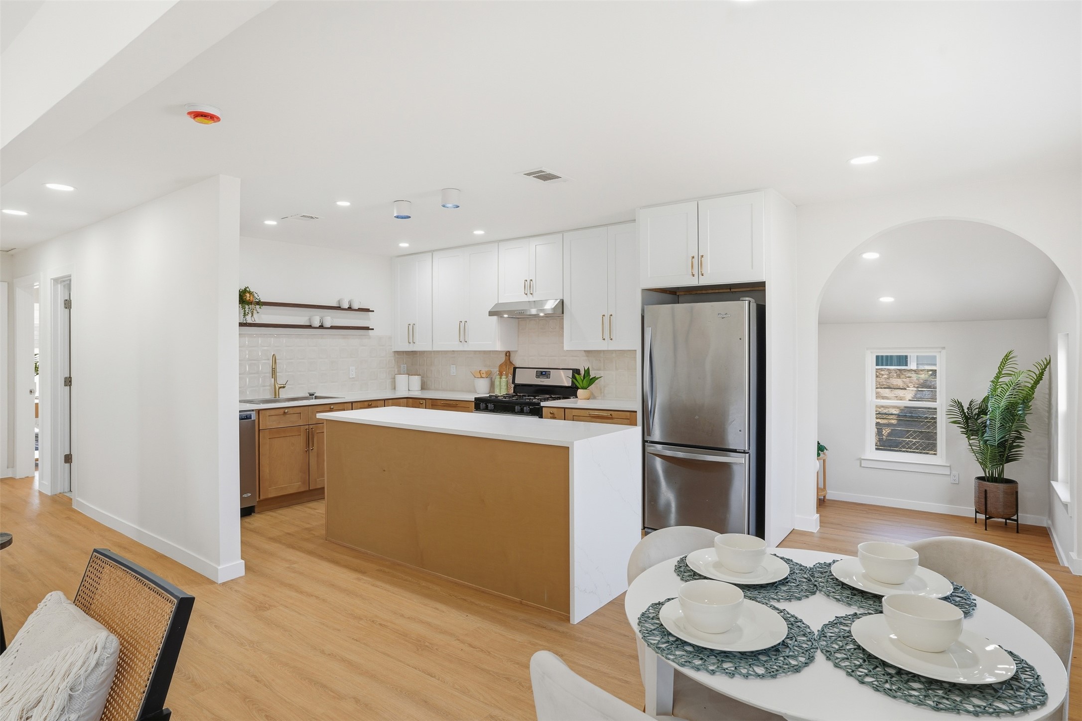 5601 Samuel Huston Avenue Austin, TX 78721 - Photo 1 of 24 Kitchen with arched walkways, stainless steel appliances, a kitchen island, light wood finished floors, and recessed lighting