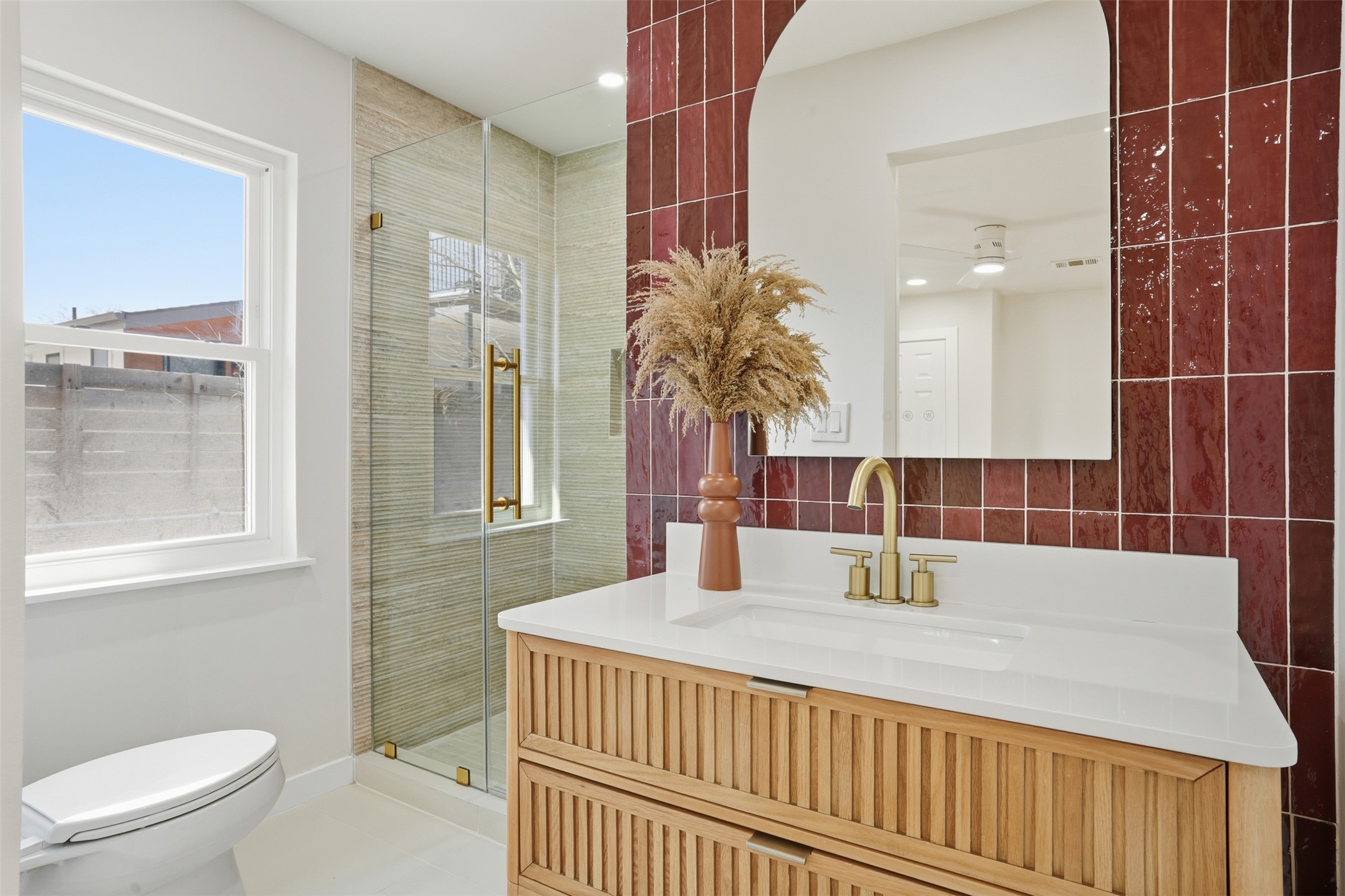 5601 Samuel Huston Avenue Austin, TX 78721 - Photo 18 of 24 Bathroom with vanity, a shower stall, and decorative backsplash