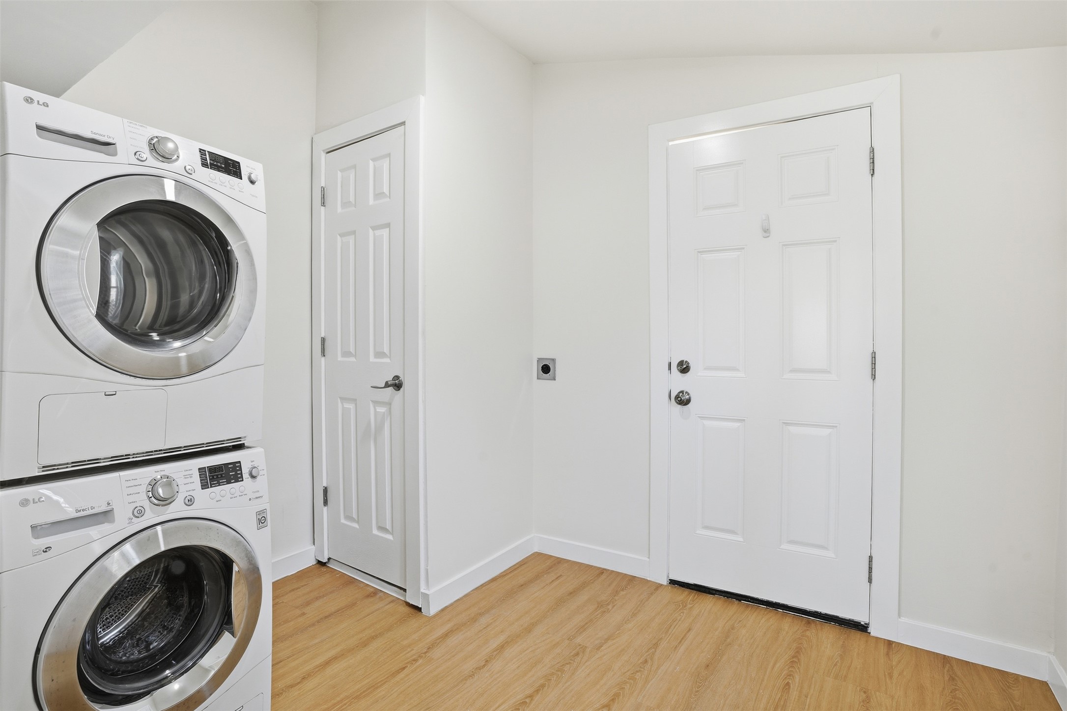 5601 Samuel Huston Avenue Austin, TX 78721 - Photo 22 of 24 Laundry room featuring light wood-type flooring, stacked washer / drying machine, and vaulted ceiling