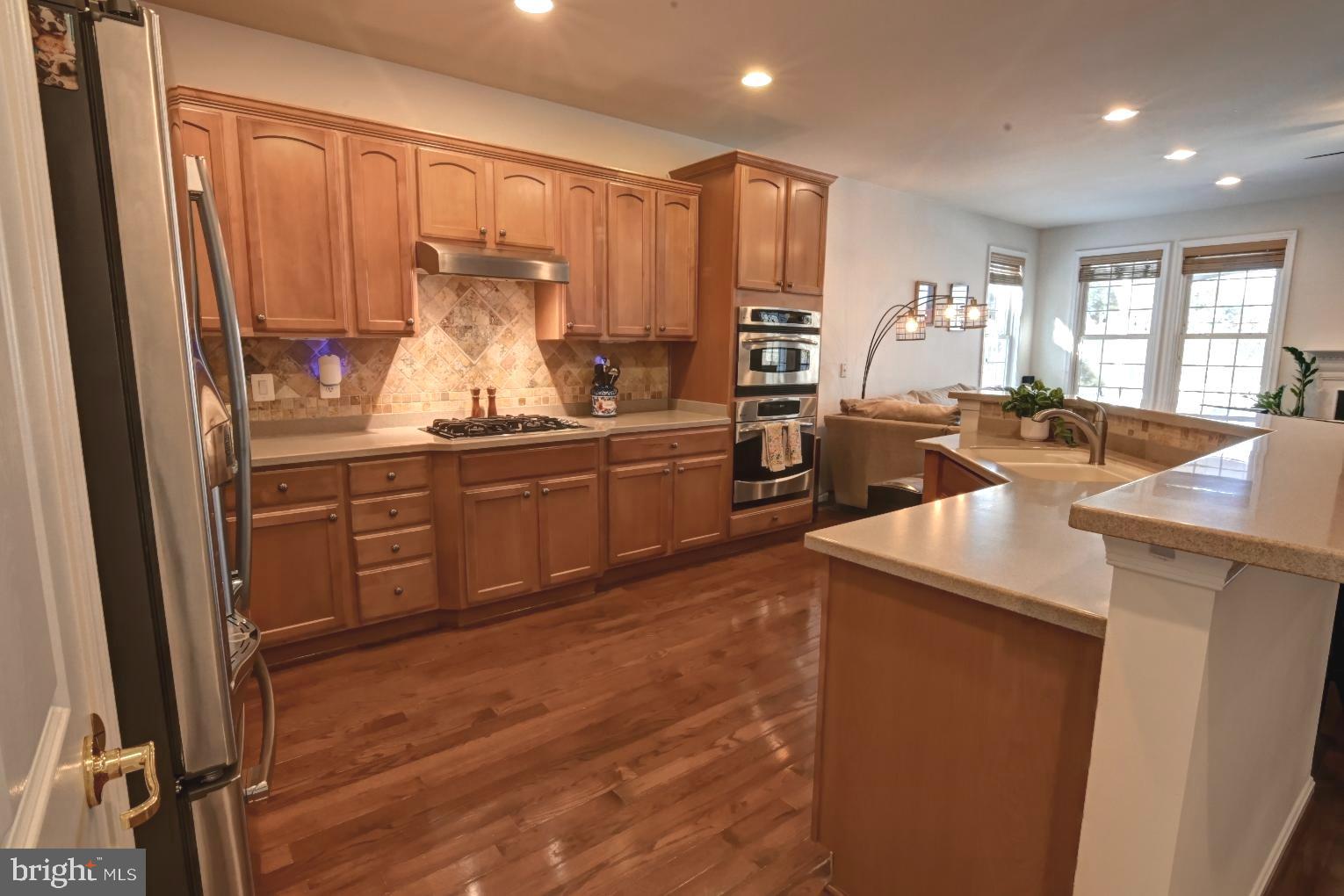 13170 Triple Crown Loop Gainesville, VA 20155 - Photo 19 of 71 a kitchen with stainless steel appliances granite countertop a sink stove and refrigerator