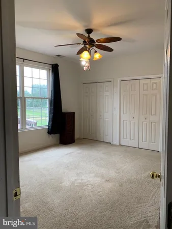 an empty room with windows and closet