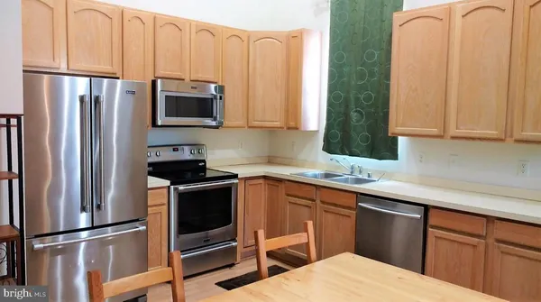 a kitchen with stainless steel appliances a stove a sink and a refrigerator with cabinets