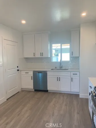a kitchen with granite countertop white cabinets and white appliances