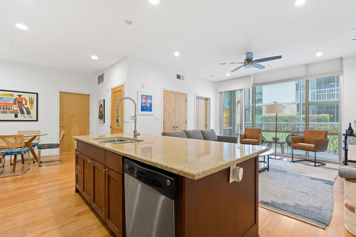 a dining hall with stainless steel appliances granite countertop a sink and a large window