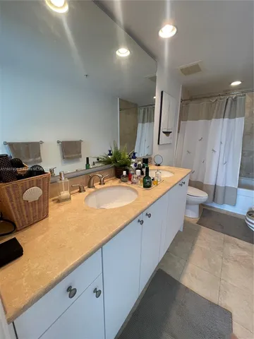 a bathroom with a double vanity sink a mirror and a bathtub
