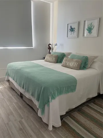 a bedroom with a bed and painting on the wall