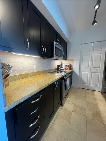 a kitchen with stainless steel appliances a stove a refrigerator and a oven