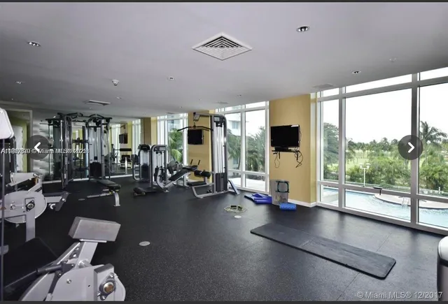 a view of a room with gym equipment and floor to ceiling window