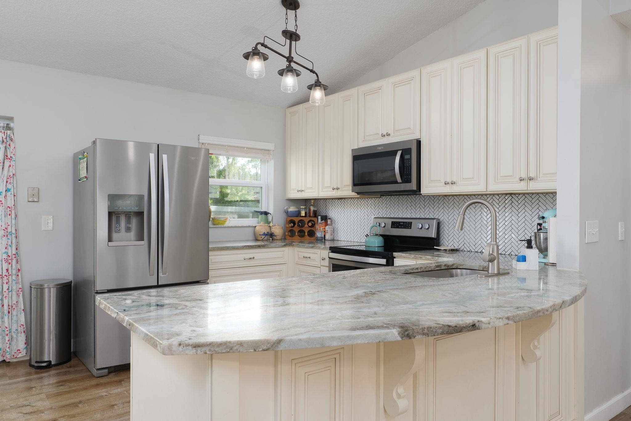 133 Mohegan Road St. Augustine, FL 32086 - Photo 9 of 24 a kitchen with stainless steel appliances granite countertop a sink stove and refrigerator
