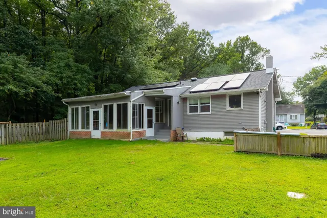 a view of a house with a yard deck and a small cabin