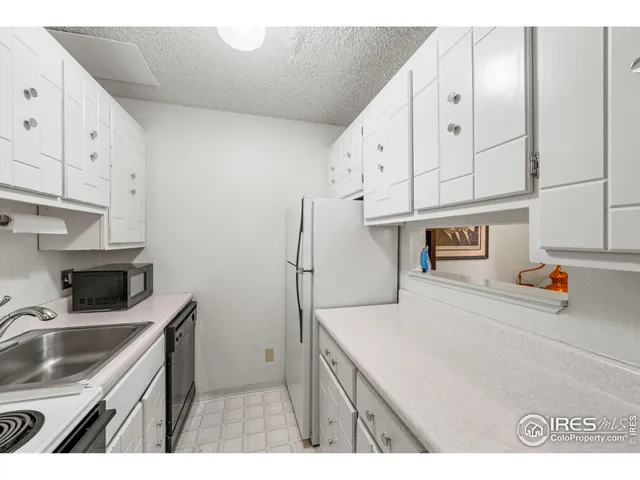 a kitchen that has a sink a stove and cabinets