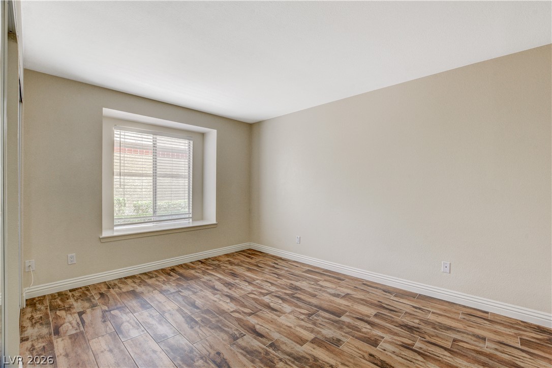 7200 West Pirates Cove Road, Unit 1026 Las Vegas, NV 89145 - Photo 22 of 35 This airy room features warm wood flooring, offering a comfortable and inviting atmosphere.