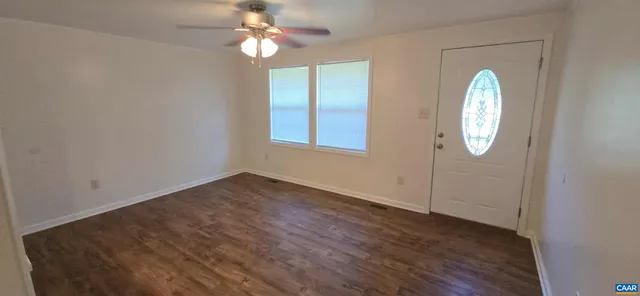 an empty room with wooden floor and a window