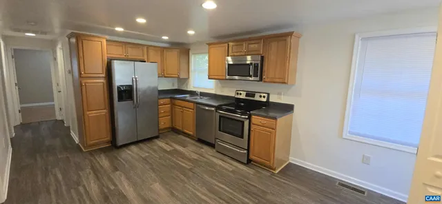 a kitchen with stainless steel appliances a refrigerator and a stove top oven
