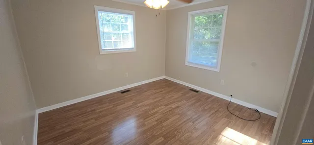 a view of a room with wooden floor and windows