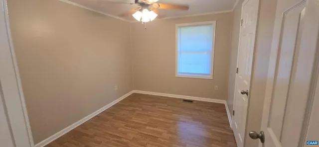 a view of an empty room with wooden floor