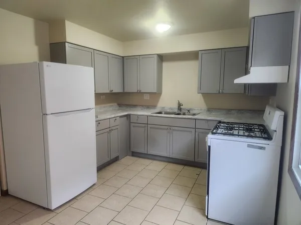 a kitchen with a sink a stove a refrigerator and cabinets