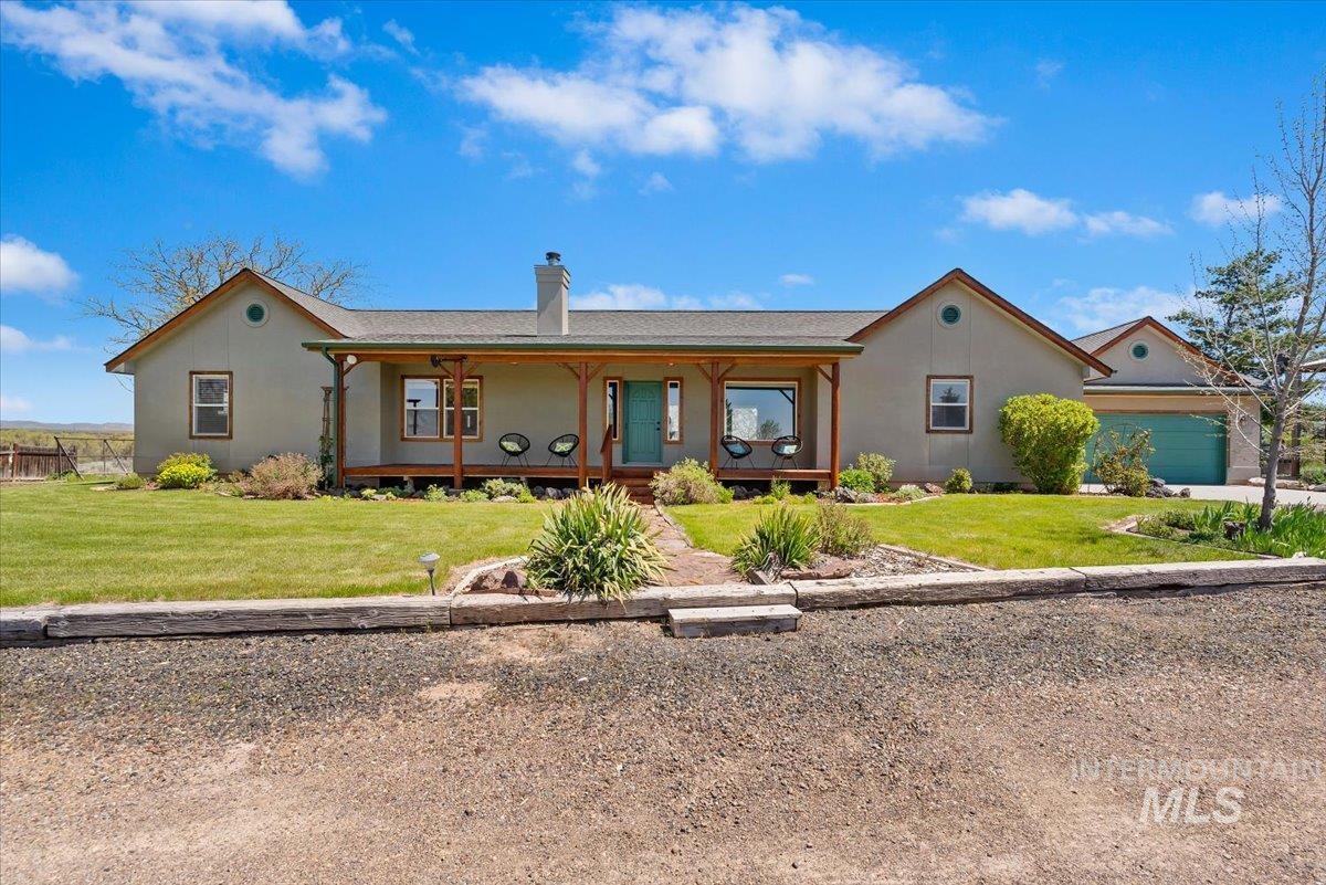 147 East Indian Crk Road Boise, ID 83716 - Photo 1 of 43 Ranch-style residence featuring a covered front porch with natural wood pillars, a central chimney, and an attached two-car garage