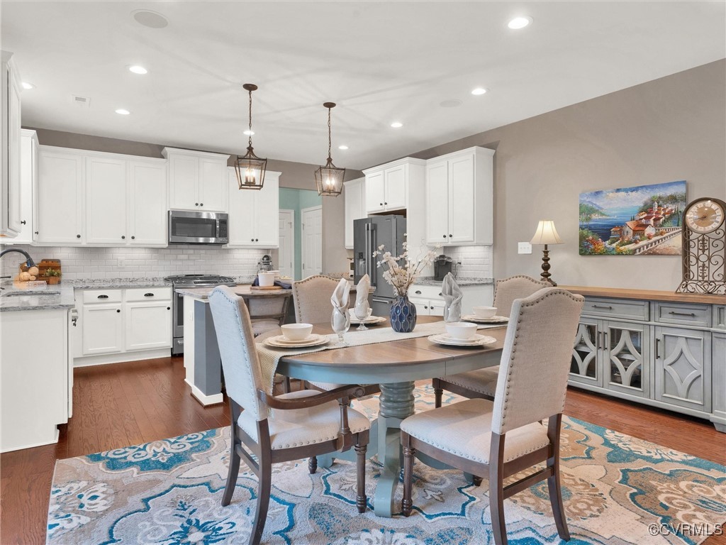 10168 Kellys Bluff Run Ashland, VA 23005 - Photo 18 of 50 a kitchen with kitchen island a dining table chairs stainless steel appliances and cabinets