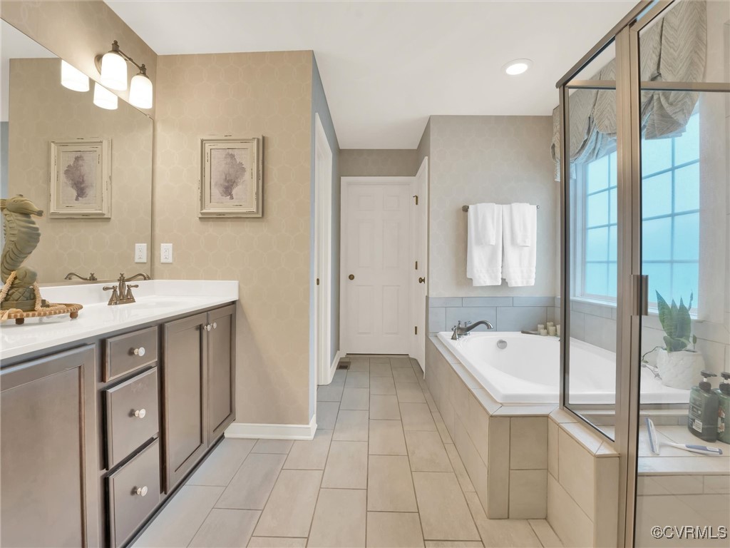 10168 Kellys Bluff Run Ashland, VA 23005 - Photo 23 of 50 a spacious bathroom with a double vanity sink a mirror and a bathtub
