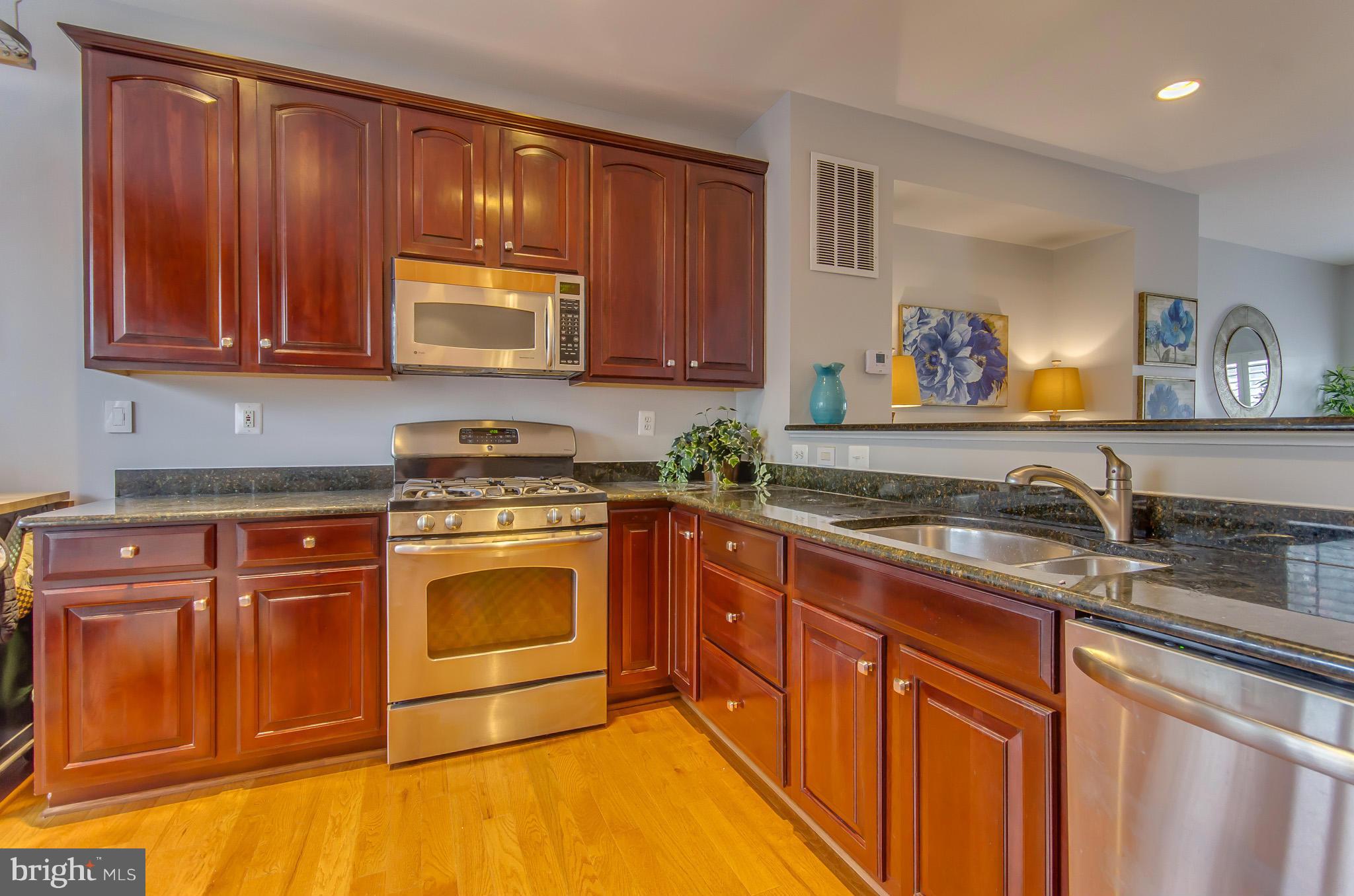 2116 12th Street Northwest Washington, DC 20009 - Photo 11 of 30 a kitchen with stainless steel appliances granite countertop a sink stove and cabinets