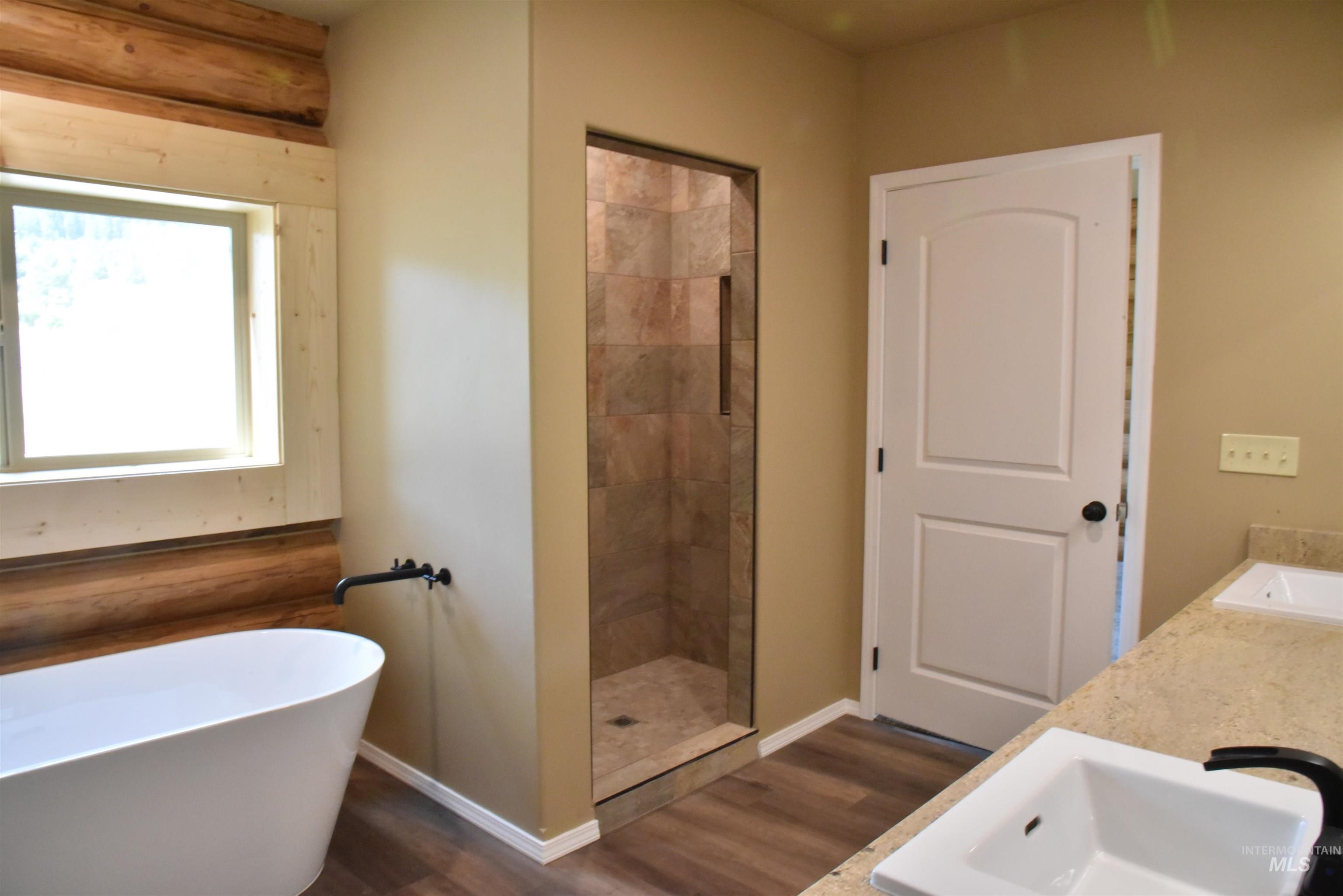 293 Vine Maple Desmet, ID 83824 - Photo 12 of 23 Full bath with dark wood-style flooring, a soaking tub, double vanity, and a shower stall