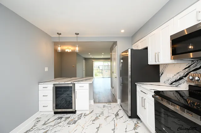 a kitchen with stainless steel appliances granite countertop a refrigerator a stove and a sink