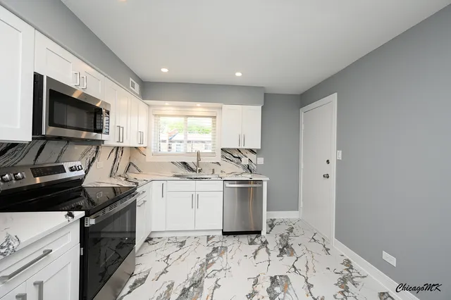a kitchen that has a sink and a stove top oven