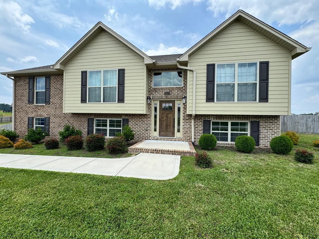 a view of house with yard and outdoor seating