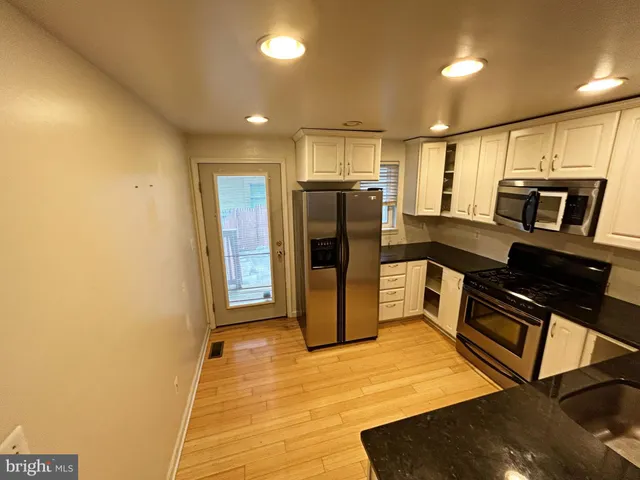 a kitchen with stainless steel appliances a refrigerator and microwave