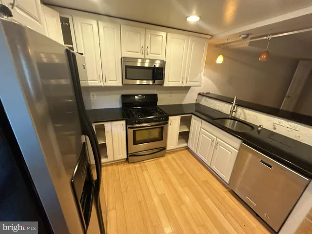 a kitchen with stainless steel appliances a refrigerator sink and microwave